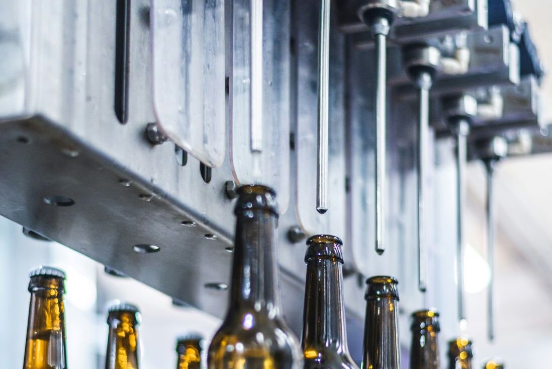 Encoders by Function Application (7) Encoders for filling applications. Image: bottles lined-up ready to be filled by machine.